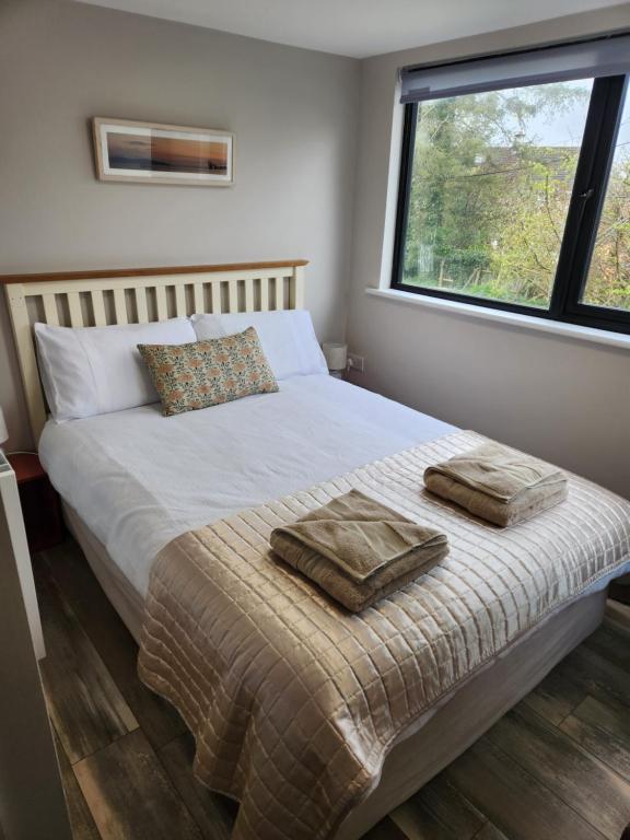 1 dormitorio con 1 cama con 2 toallas en Atlantic Way Urban Escape en Galway