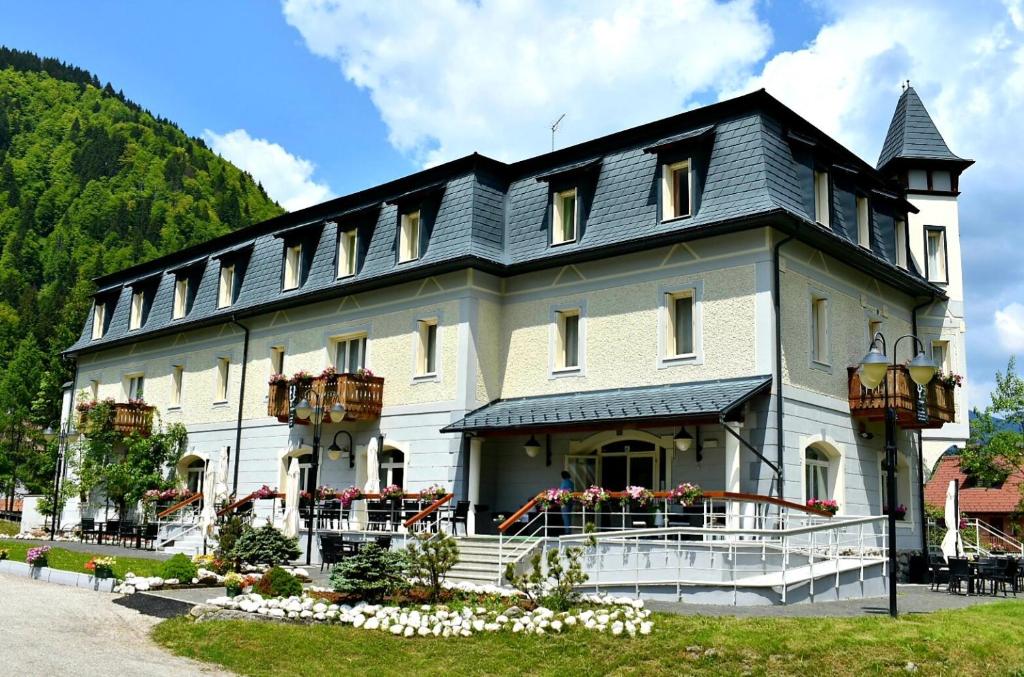 un gran edificio blanco con techo negro en Hotel Saisera, en Valbruna