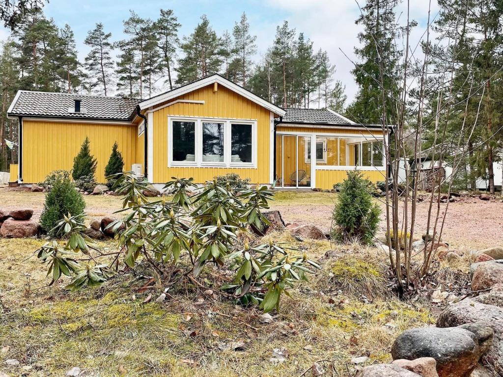a yellow house in the middle of a yard at Holiday home Mönsterås VII in Mönsterås