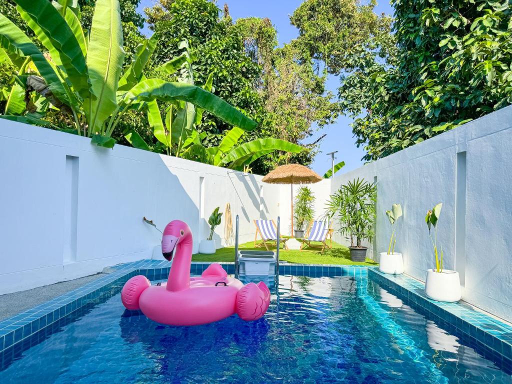 a pink inflatable pink flamingo in a swimming pool at White Castle in Panwa Beach