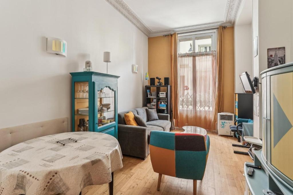 uma sala de estar com uma mesa e um sofá em Charmant appartement en plein coeur du Marais em Paris