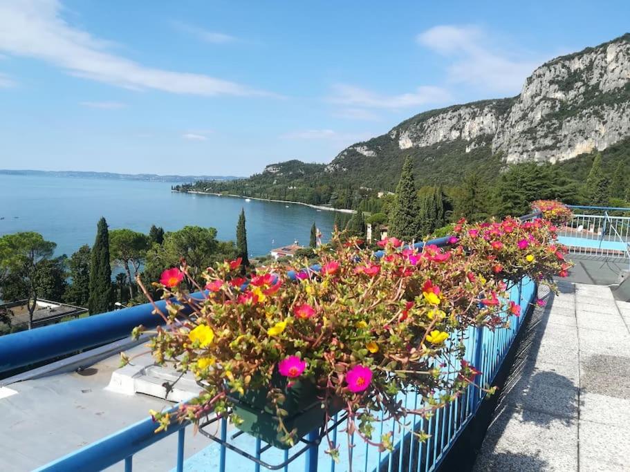 a bunch of flowers on a balcony overlooking the water at Star on the lake in Garda