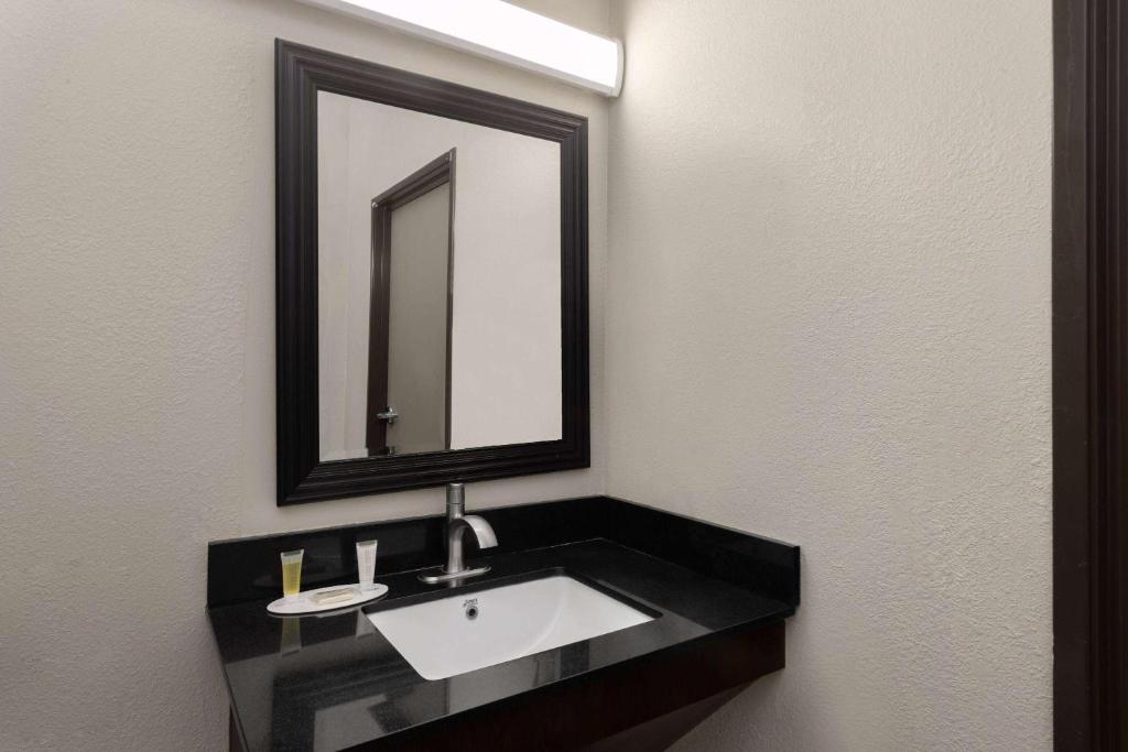 y baño con lavabo y espejo. en Days Inn & Suites by Wyndham Tucson/Marana, en Tucson