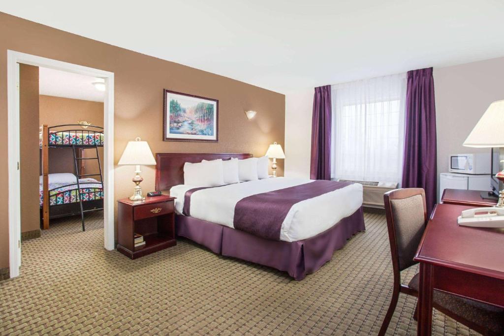 Postel nebo postele na pokoji v ubytování Ramada by Wyndham Red Deer Hotel & Suites