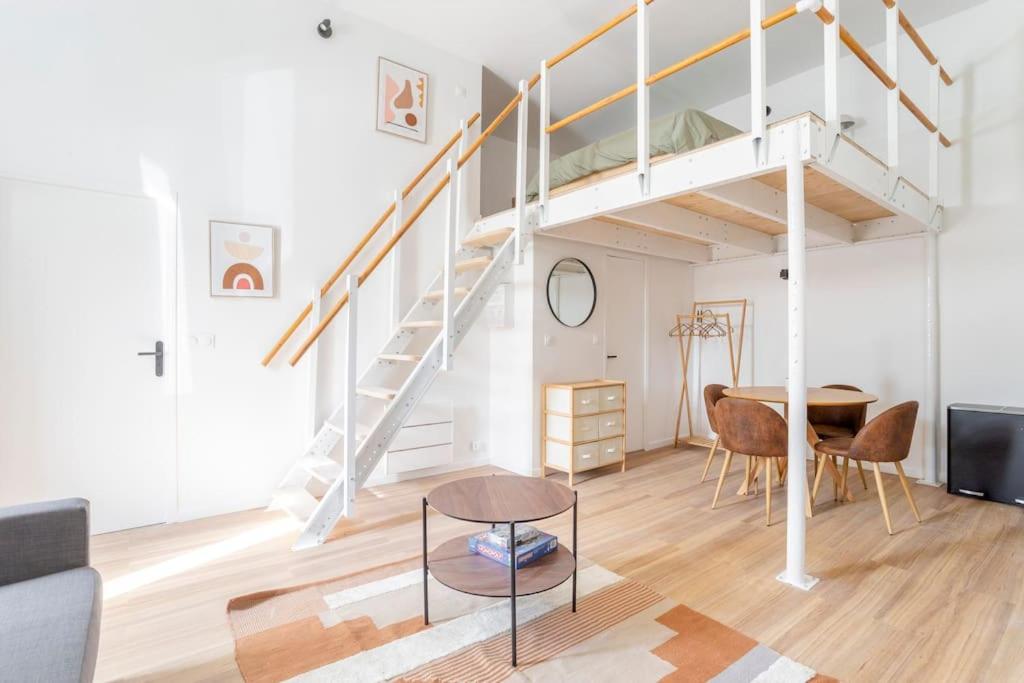 een woonkamer met een trap en een tafel bij Lille Bel appartement Cosy avec Mezzanine in Lille
