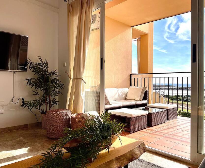 ein Wohnzimmer mit einem Sofa und einem Balkon in der Unterkunft Apartment with sea-view in Golf Bonalba Alicante in Mutxamel
