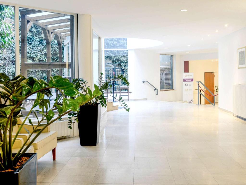 a hallway with potted plants in a building at Hotel Mercure Wien Westbahnhof in Vienna