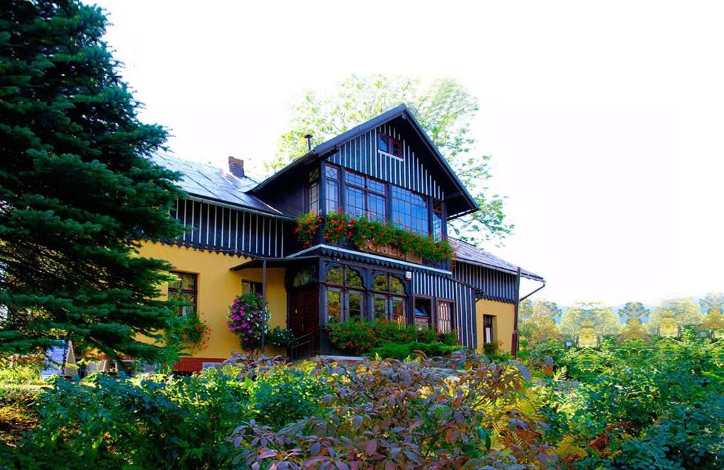 a black and yellow house with flowers in front of it at Dom Polana Karpacz in Karpacz
