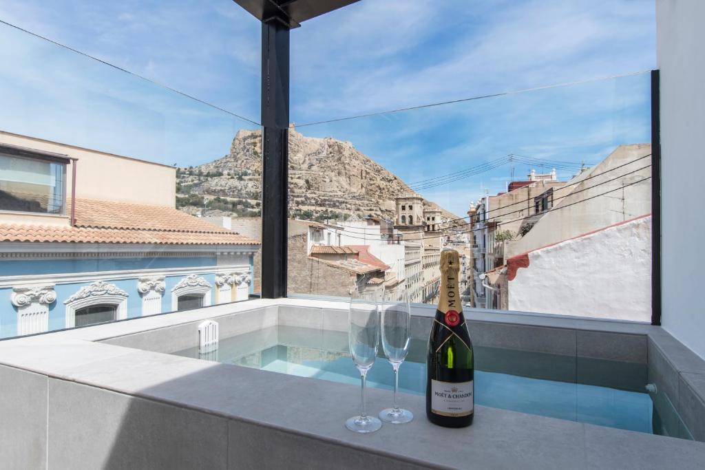 a bottle of wine and two glasses on a balcony at RS Boutique Apartments in Alicante