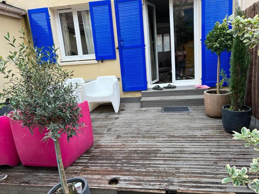a house with blue doors and a porch with plants at Maison 8 voyageurs à 15mn des champs élysées in Asnières-sur-Seine