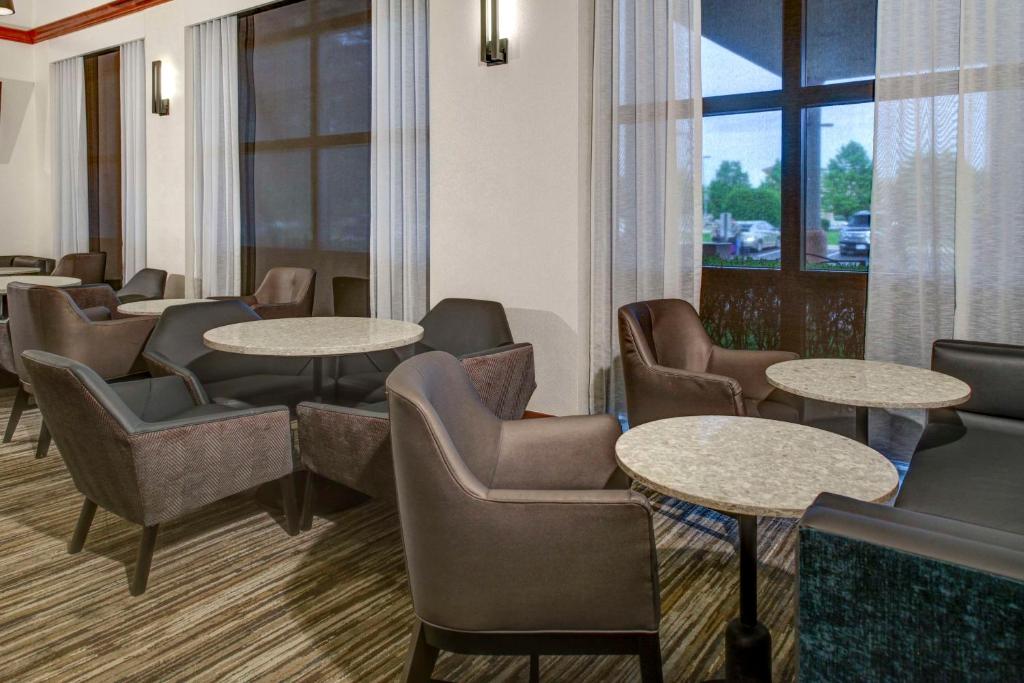 ein Wartezimmer mit Tischen und Stühlen und einem Fenster in der Unterkunft Hyatt Place Detroit/Auburn Hills in Auburn Hills