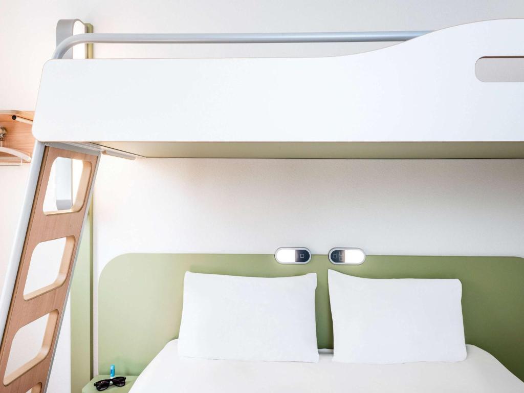 a bedroom with a bunk bed with two pillows at ibis budget Honfleur Centre in Honfleur