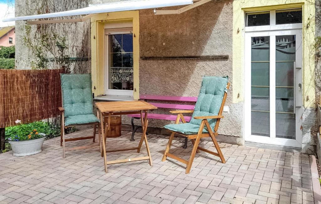 2 chaises et une table en bois sur la terrasse dans l'établissement 1 Bedroom Lovely Apartment In Schwarzenberg, à Schwarzenberg