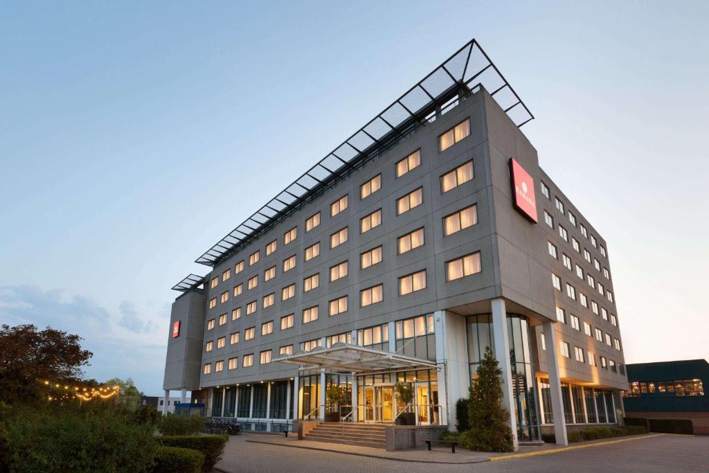 a large gray building with a lot of windows at Ramada by Wyndham Amsterdam Airport Schiphol in Badhoevedorp