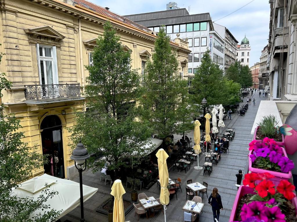 uma rua com mesas e cadeiras numa cidade em Princ Apartment em Belgrado