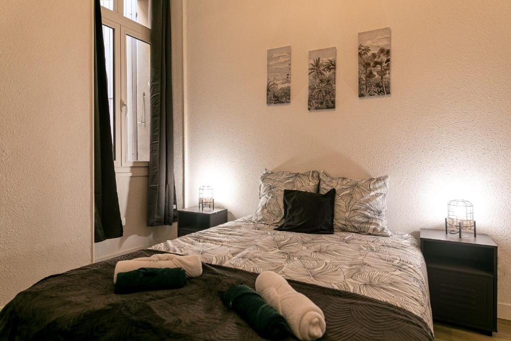 a bedroom with a bed with two tables and two pictures on the wall at Lumineux T5 - Climatisation in Perpignan
