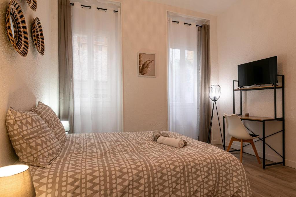 a small bedroom with a bed and a television at Lumineux T5 - Climatisation in Perpignan