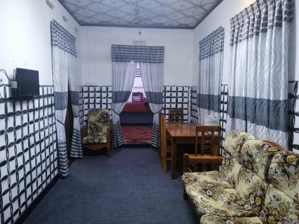 ein Wohnzimmer mit einem Sofa und einem Tisch in der Unterkunft ZAHIRA Beach Place Kattankudy in Kattankudi