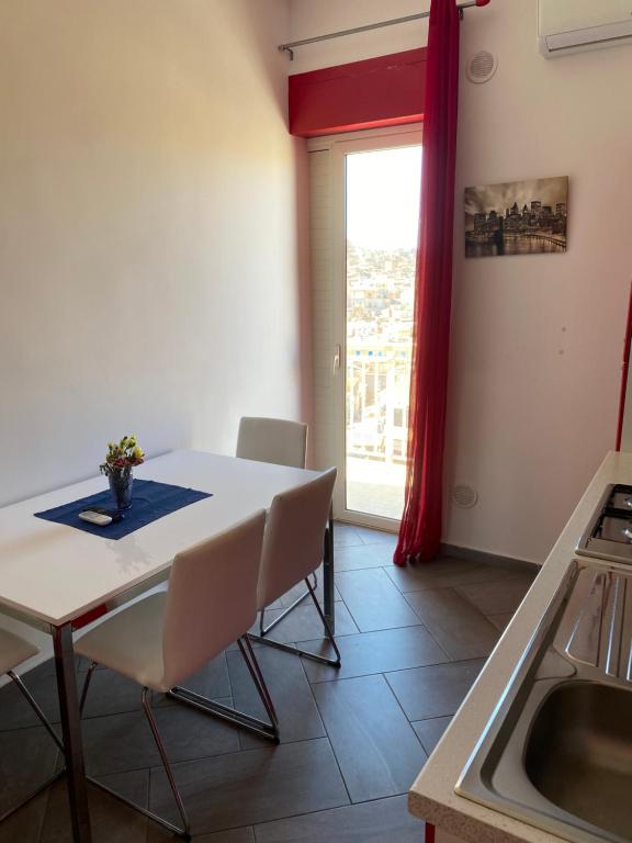 a kitchen with a table and chairs and a window at Rossa Chupiteria The Time Avanzato in Licata