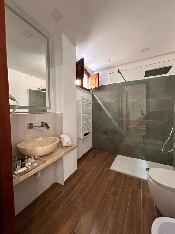 a bathroom with a sink and a glass shower at Luxury Studio Suite in Niscemi