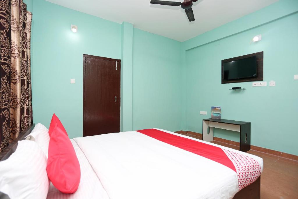 a bedroom with a bed and a flat screen tv at Flagship The Maple Tree Hotels in Bhubaneshwar