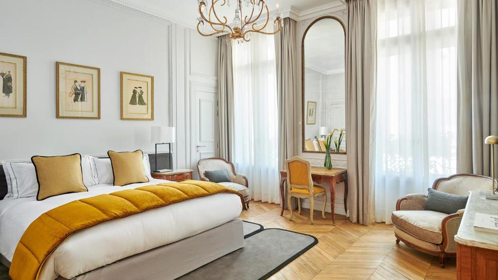 فندق لانكاستر باريس شانزليزيه في باريس: غرفة نوم بسرير وطاولة وكراسي