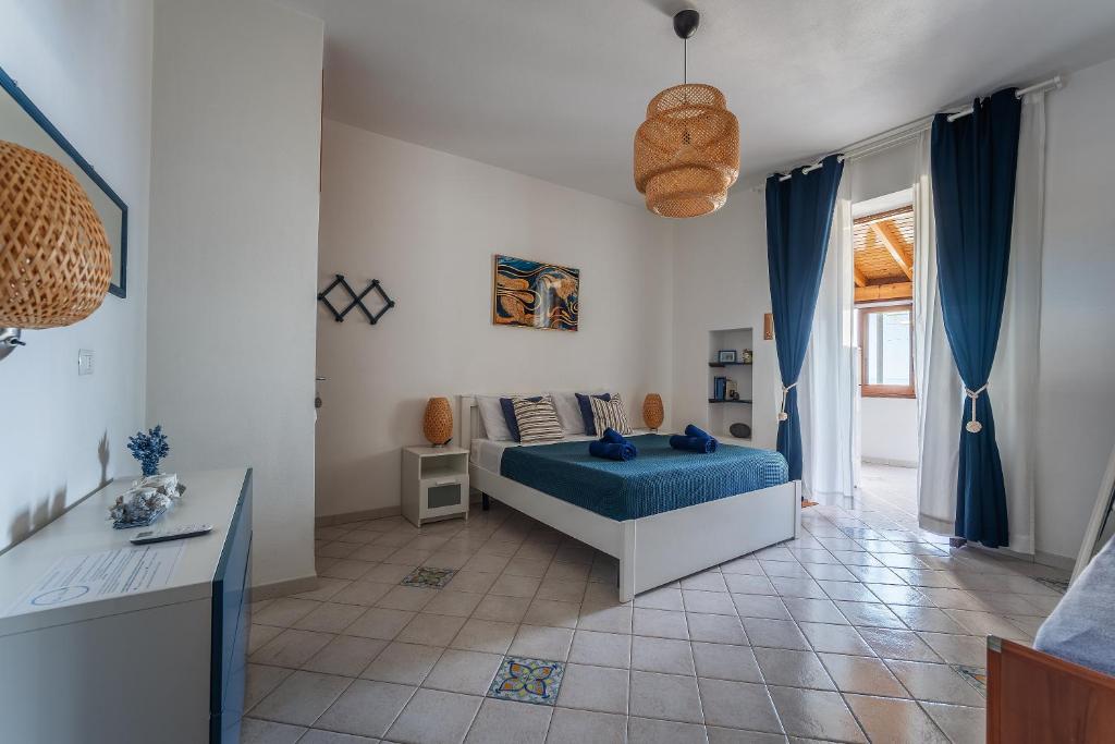 a bedroom with a blue bed and a table at Casa Norma in Lipari