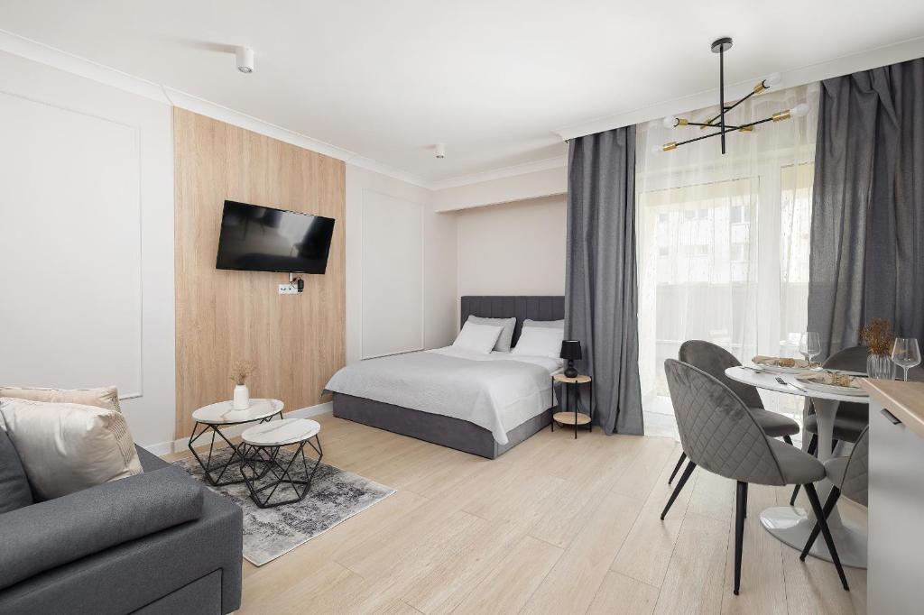 Una habitación de hotel con una cama y una sala de estar. en Modern Studio with Garden in Świnoujście by Noclegi Renters, en Świnoujście