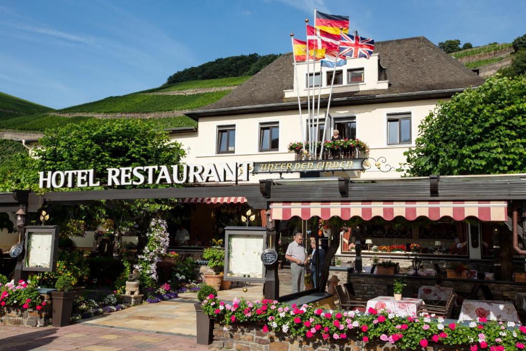 a hotel restaurant with two people standing in front of it at Hotel Unter den Linden in Rüdesheim am Rhein