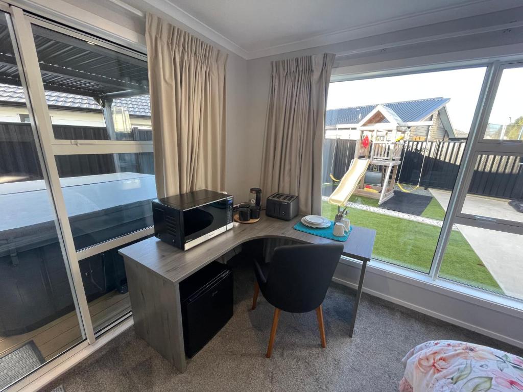 a room with a desk with a television and a bed at Private Ensuite with Spa in Upper Hutt in Upper Hutt