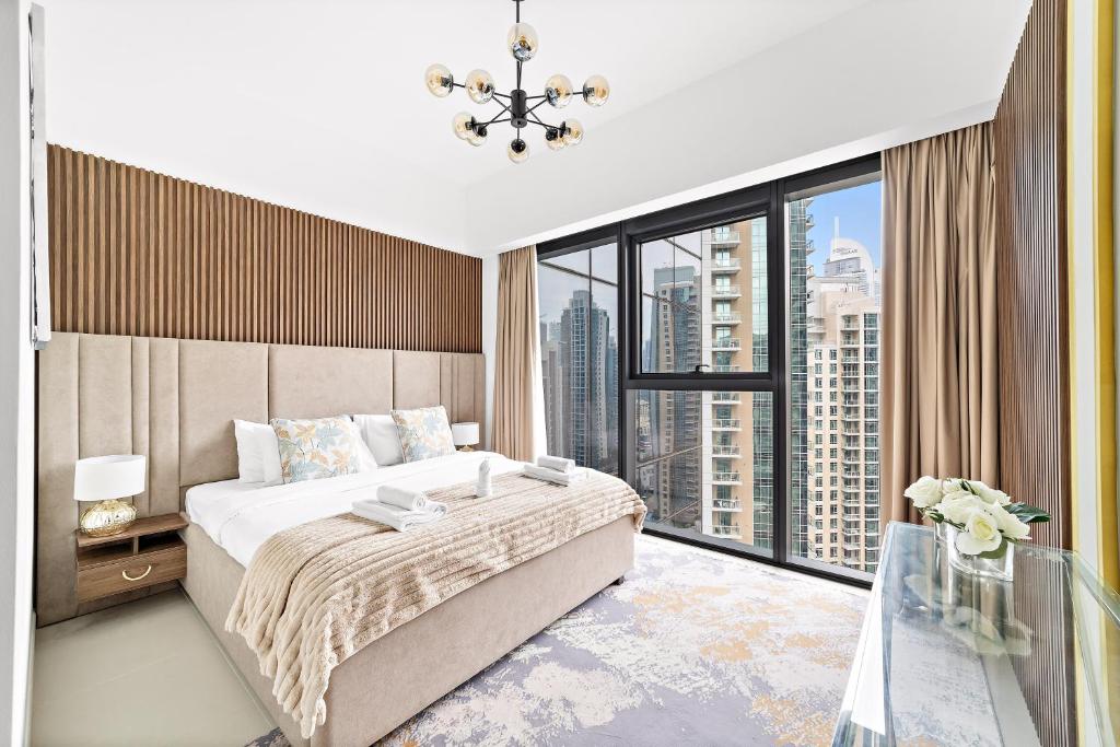Luxury 2 Bedroom Apartment - Next to Dubai Opera في دبي: غرفة نوم بسرير كبير ونافذة كبيرة