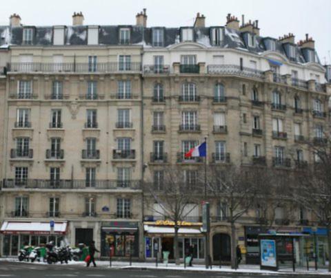 een groot gebouw met een vlag ervoor bij Jeux olympiques Paris colocation chambre double dans F3 in Parijs