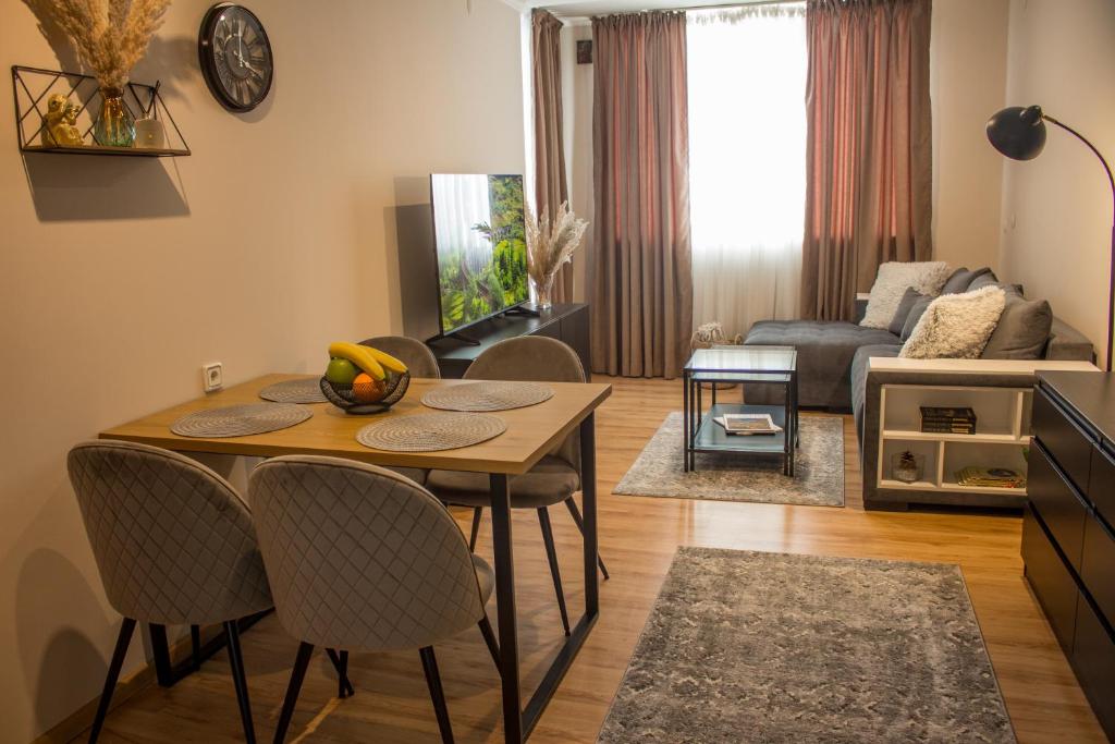 ein Wohnzimmer mit einem Tisch, Stühlen und einem Sofa in der Unterkunft EVIAS Apartment in Sandanski