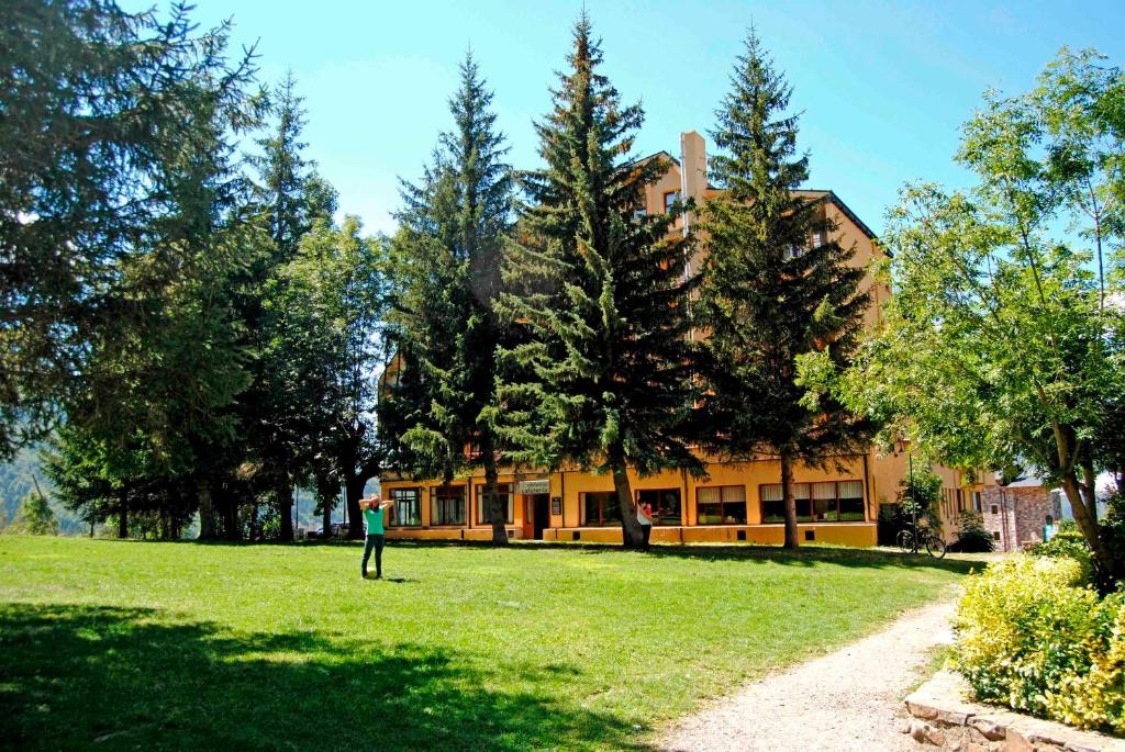 a person standing in a field in front of a building at Apartamentos SNÖ Edelweiss in Cerler