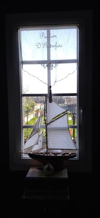 un bateau modèle dans une fenêtre d'une maison dans l'établissement Une chambre en ville, à Domfront