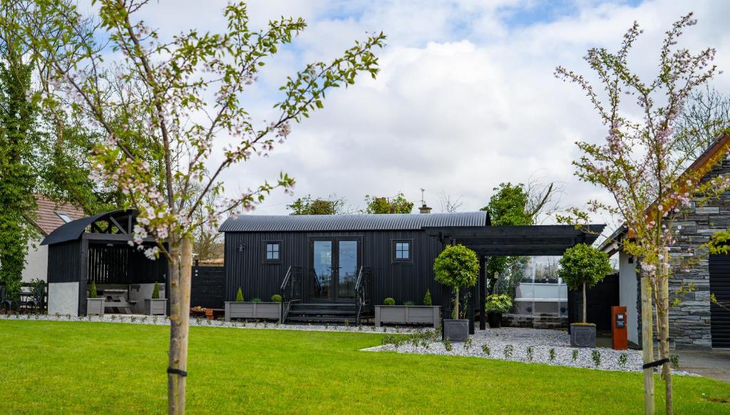 una casa negra con techo negro en Cherry Tree Lodge, en Limavady