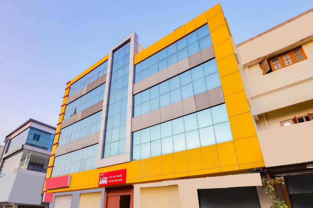 a building with yellow and blue windows on a street at OYO Jk Inn in Narasimharaja Puram
