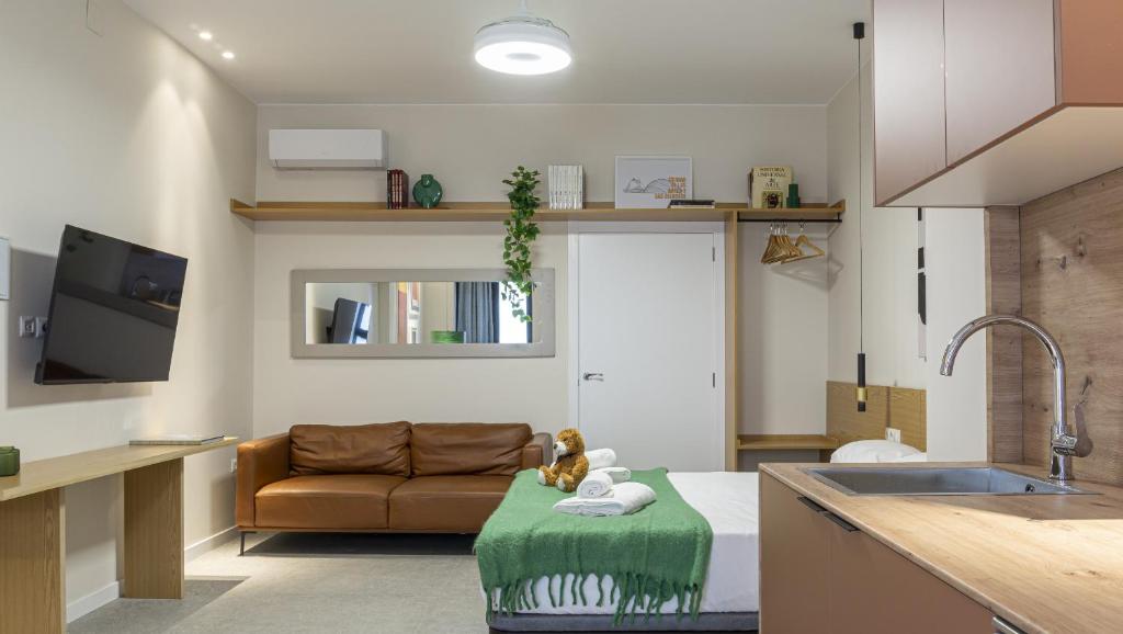 ein Wohnzimmer mit einem Sofa und einer Küche in der Unterkunft Osito Hub - Duc de Gaeta in Valencia