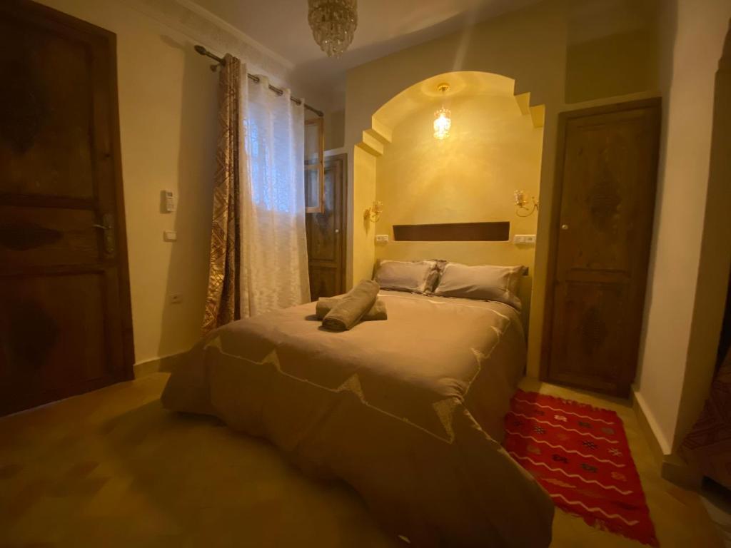 - une chambre avec un lit avec un miroir et une fenêtre dans l'établissement SOUS LE SOLEIL Chez Jérôme et Pamela chambre Marrakchi, à Marrakech