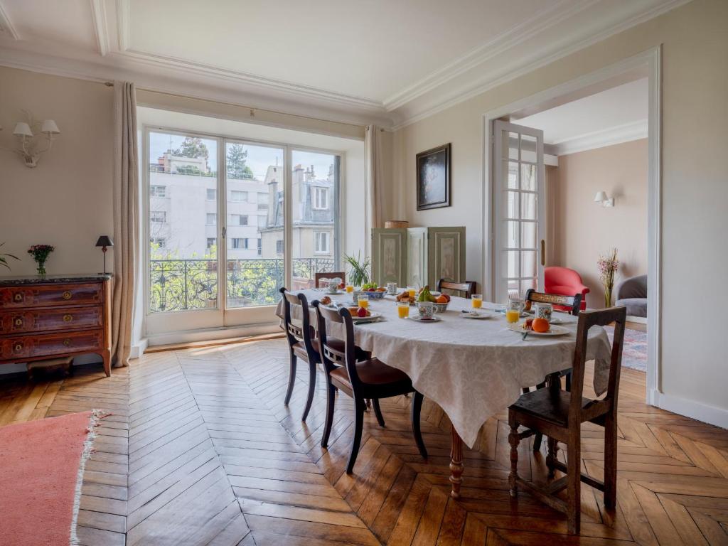 een eetkamer met een tafel en stoelen in een kamer bij Paris South Garden Residence in Saint-Cloud