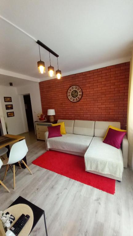 een woonkamer met een bank en een rode bakstenen muur bij MK Apartament II in Rzeszów