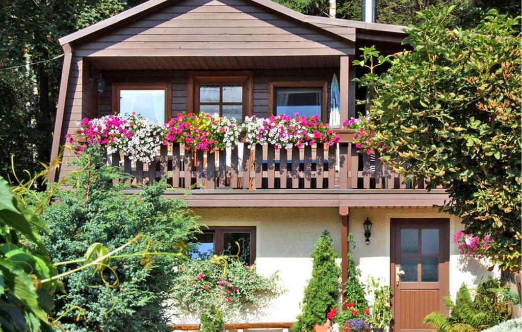 una casa con un balcón con flores. en 2 Bedroom Stunning Home In Rechenberg-bienenmhle, en Rechenberg-Bienenmühle