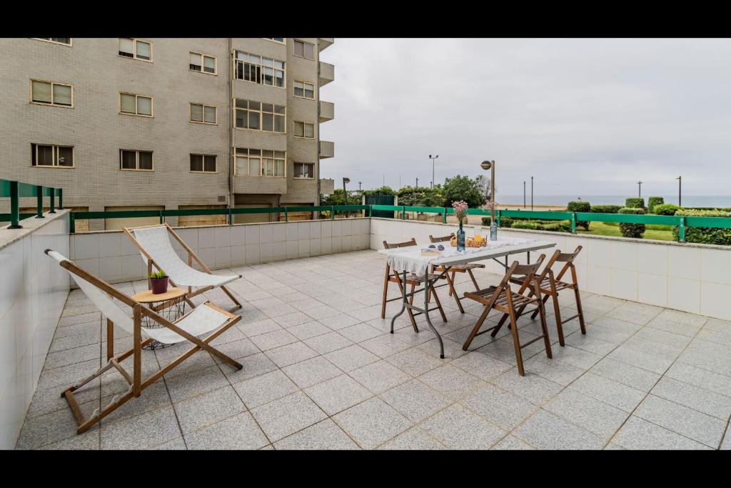 a patio with a table and chairs on a balcony at Três Marias by LovelyStay in Aver-o-Mar