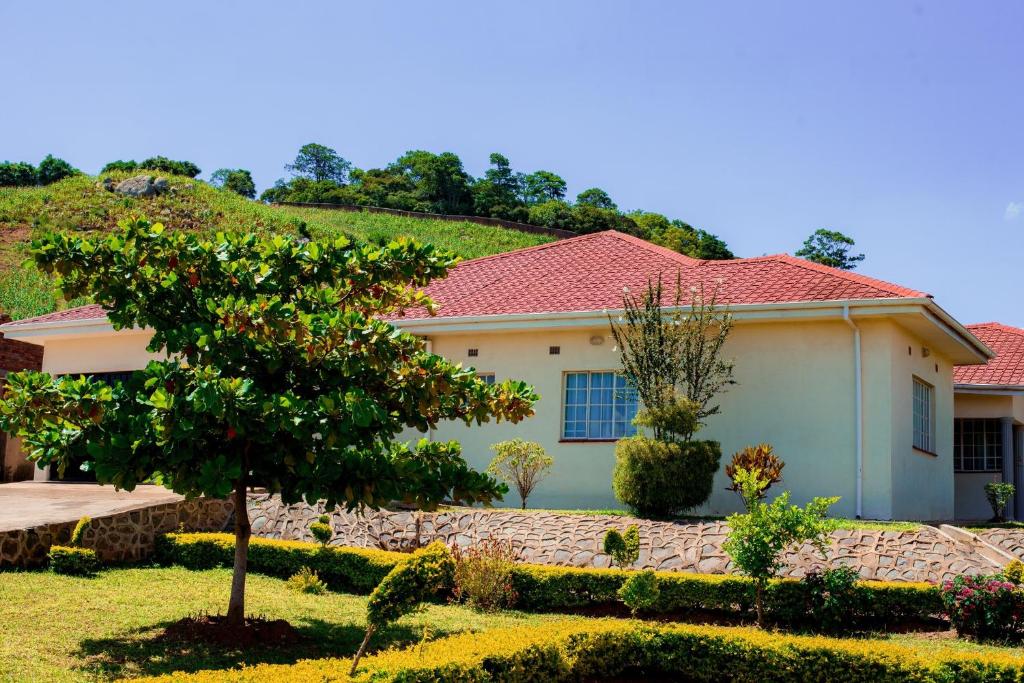 une maison blanche avec un toit rouge dans l'établissement Hillside Luxury Lodge, à Blantyre