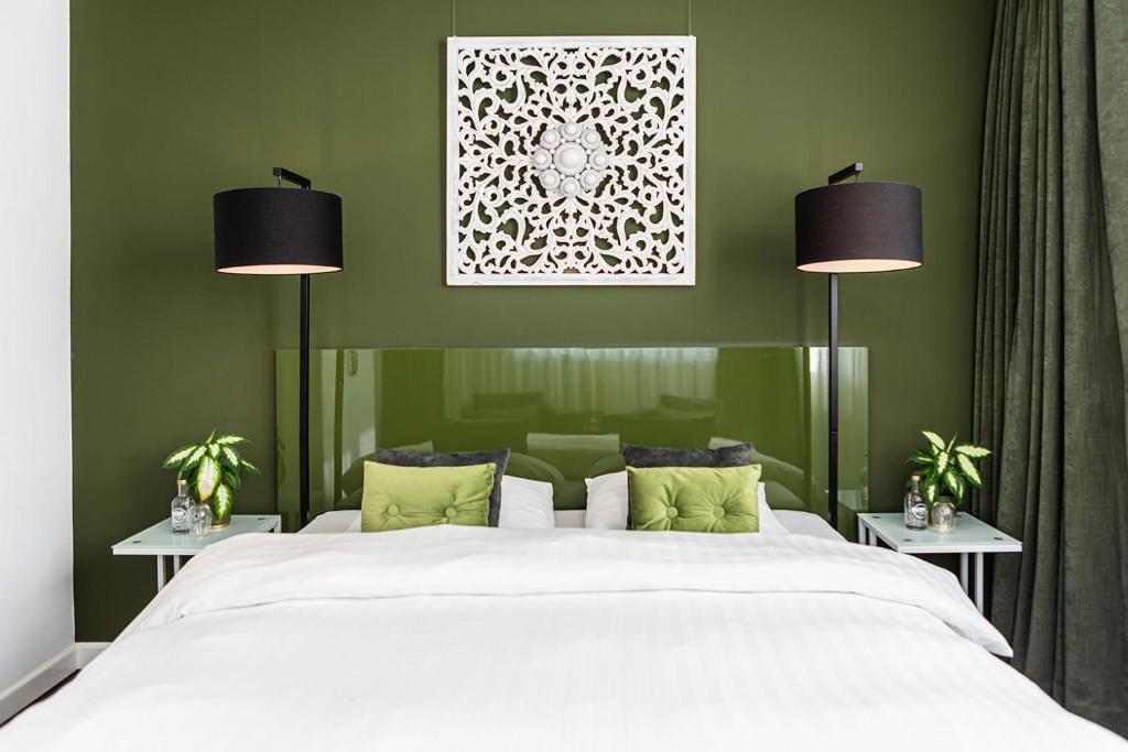 a bedroom with a large white bed with two lamps at Pension Montmaertre in Zierikzee