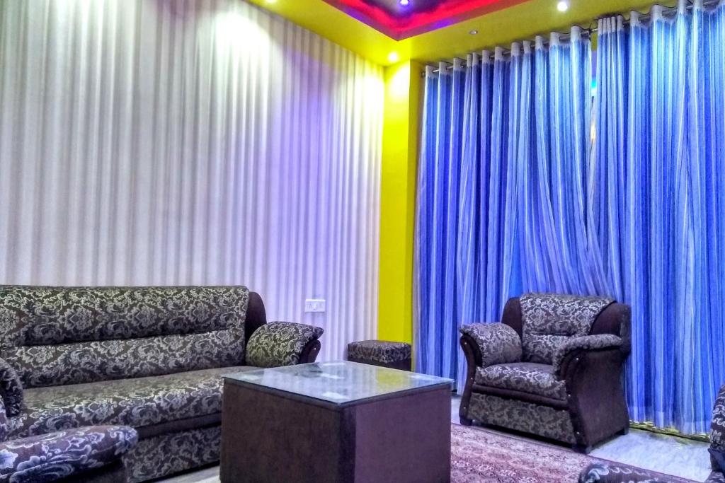 uma sala de estar com um sofá e uma cadeira em Collection O Shivanya Guest House em Kakarmatha