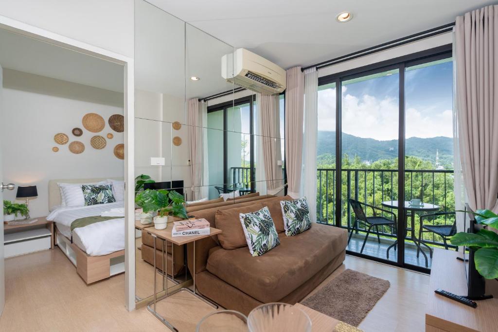 a living room with a couch and a bed at ZcapeX2 Condo near Boat Avenue & Laguna in Bang Tao Beach