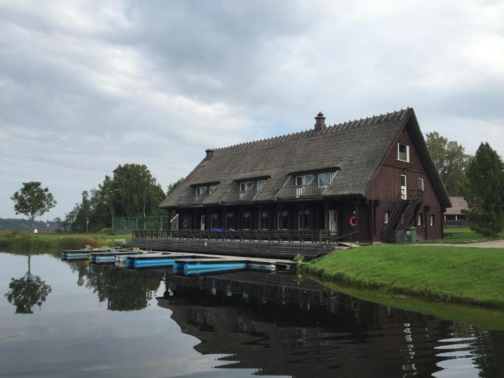 a house sitting on the water next to a river at Sammuli Holiday Village in Viljandi