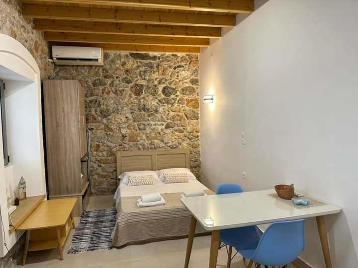 a bedroom with a bed and a desk and a table at SPITAKI in Kalymnos