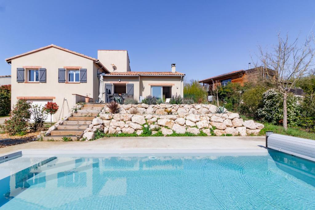 uma casa com piscina em frente a uma casa em La Tendresse - Maison Familliale avec Piscine em Mondonville